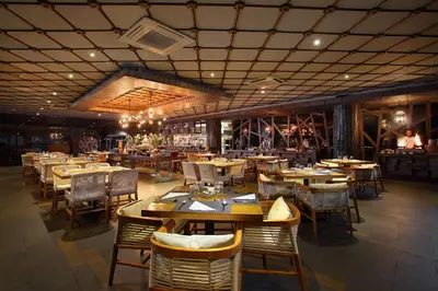 a restaurant with wooden tables and chairs and a bar at The Crystal Luxury Bay Resort Nusa Dua in Nusa Dua