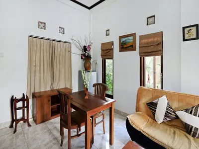 a living room with a table and a couch at Rumah Akira Seminyak in Seminyak