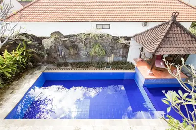 a swimming pool in front of a house at Rumah Akira Seminyak in Seminyak