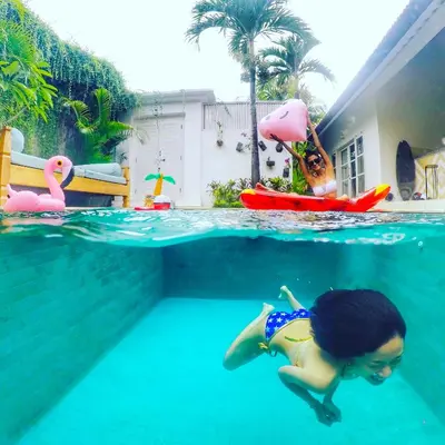 a young girl swimming in a swimming pool at Villa Niluh in Canggu