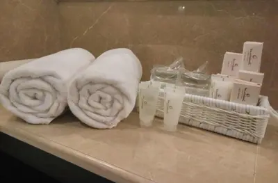 two towels are sitting on a counter in a bathroom at Jambuluwuk Oceano Seminyak Hotel in Seminyak