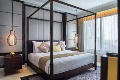 a bedroom with a canopy bed and a window at Jambuluwuk Oceano Seminyak Hotel in Seminyak