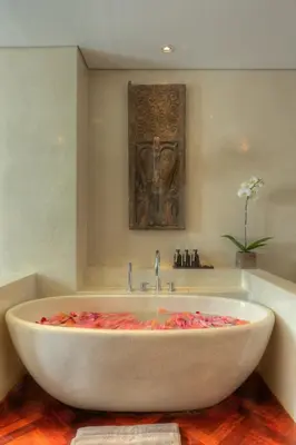 a bath tub in a bathroom with a sink at Amanputri Villa in Seminyak