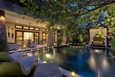a swimming pool with lights in a house at Amanputri Villa in Seminyak