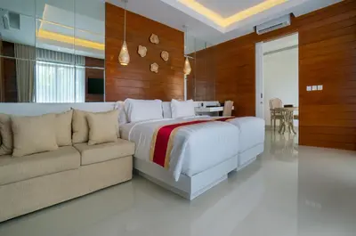 a bedroom with a large bed and a couch at Sithala Villa Seminyak in Seminyak