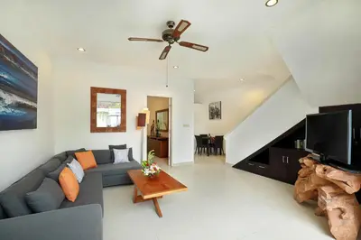 a living room with a couch and a tv at Villa Lamac in Legian