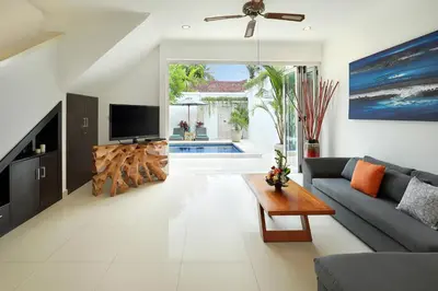 a living room with a couch and a tv at Villa Lamac in Legian