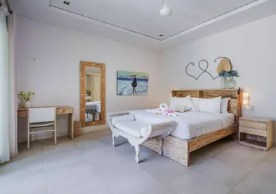 a bedroom with a bed and a desk and a mirror at Bali Villa Beachfront Luxe Rooftop Sunsets in Canggu