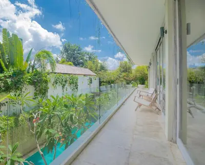 a balcony with a view of a garden at Bali Villa Beachfront Luxe Rooftop Sunsets in Canggu