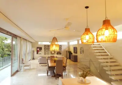a living room with a staircase and a dining room at Bali Villa Beachfront Luxe Rooftop Sunsets in Canggu