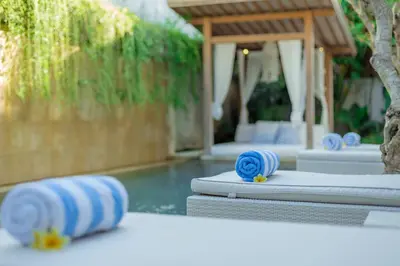 a pool with blue and white rolled up towels at Bali Villa Beachfront Luxe Rooftop Sunsets in Canggu