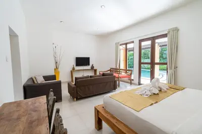 a bedroom with a bed and a living room at Villa Aveli Seminyak by Best Deals Asia Hospitality in Seminyak