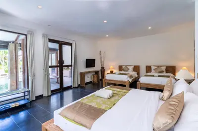 a large bedroom with two beds and a television at Villa Aveli Seminyak by Best Deals Asia Hospitality in Seminyak