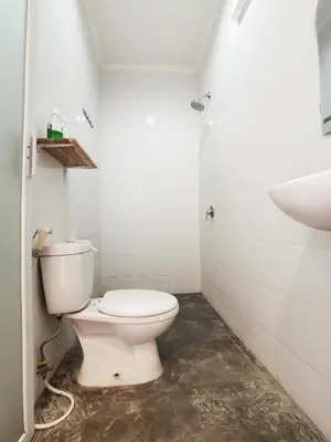 a bathroom with a toilet and a sink at Nuka Beach Inn in Kuta