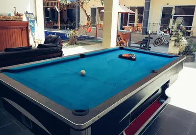 a pool table in the middle of a living room at Nuka Beach Inn in Kuta