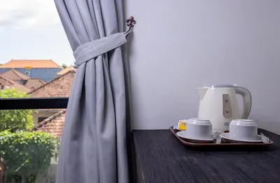 a table with a coffee maker and cups on a window at The Aswana Seminyak in Seminyak