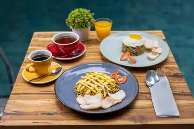 a table with two plates of food and two cups of coffee at The Aswana Seminyak in Seminyak