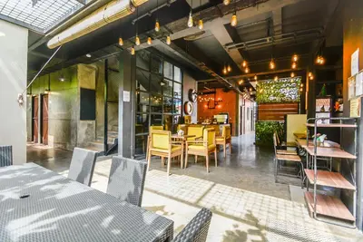 a dining room with yellow chairs and tables in a restaurant at The Aswana Seminyak in Seminyak