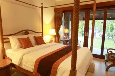 a bedroom with a large bed with a large window at Adys Inn in Legian