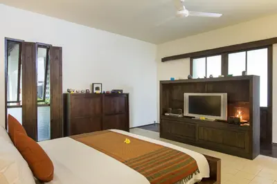 a bedroom with a bed and a television in it at Villa Roku by Nagisa Bali in Seminyak