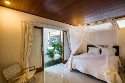 a bedroom with a bed with a canopy at Villa Kamboja Deluxe in Seminyak