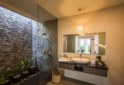 a bathroom with a sink and a mirror at Villa Kamboja Deluxe in Seminyak