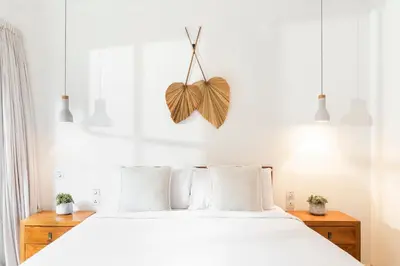 a bedroom with a large bed with white sheets and a butterfly decoration at Villa Wahah in Seminyak