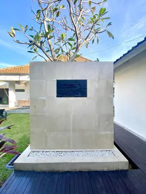 a concrete wall with a tree in the middle at Villa EMMA | heart of Seminyak | 350m Beach in Seminyak