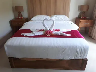a bed with two towels in the shape of hearts at Guest House Reisya in Nusa Dua