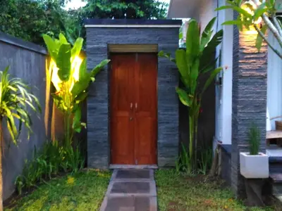 a wooden door in the side of a house at Guest House Reisya in Nusa Dua