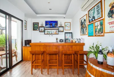 a bar in a restaurant with wooden tables and chairs at Rama Residence Padma in Legian