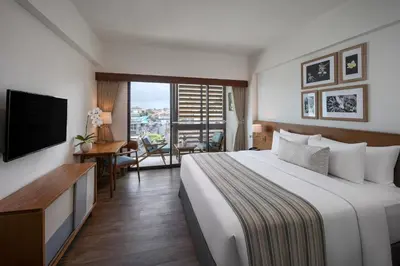a hotel room with a bed and a television at Rama Residence Padma in Legian