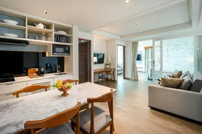 a kitchen and living room with a table and a couch at Rama Residence Padma in Legian