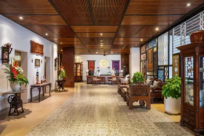 a lobby with wooden ceilings and tables and chairs at Rama Residence Padma in Legian