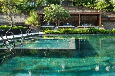 a swimming pool in front of a house at Hotel Indigo Bali Seminyak Beach by IHG in Seminyak