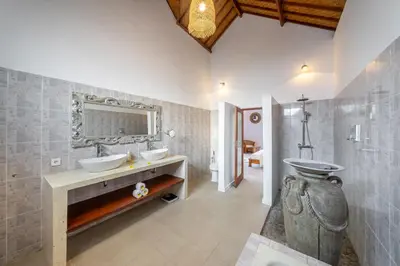 a bathroom with two sinks and a mirror at Villa Mangga 3 chambres seminiak in Seminyak