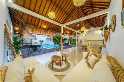 an open living room with a couch and a table at Villa Mangga 3 chambres seminiak in Seminyak