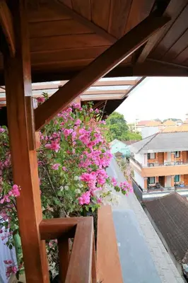 a balcony with pink flowers on a building at Seahouse Bali Indah Beach Inn in Kuta