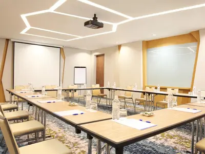 a conference room with tables and chairs and a podium at Holiday Inn Express Baruna by IHG in Kuta