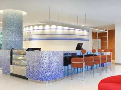 a kitchen with a blue and white counter and chairs at Holiday Inn Express Baruna by IHG in Kuta