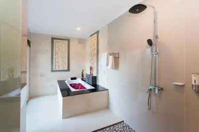 a bathroom with a shower and a sink at Kubu Petitenget Suite Seminyak in Seminyak