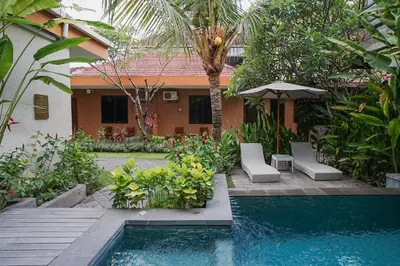 a backyard with a swimming pool and a house at Dee Mansion Bali in Denpasar