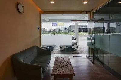 a living room with a couch and a car parked outside at Dee Mansion Bali in Denpasar