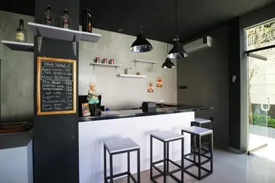 a kitchen with a bar with stools and a chalkboard at Dee Mansion Bali in Denpasar