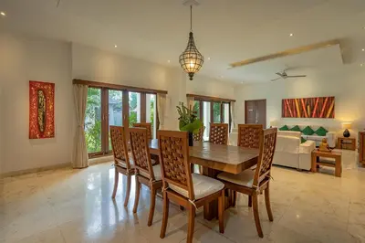 a dining room with a wooden table and chairs at Bali Villa Lotus in Seminyak