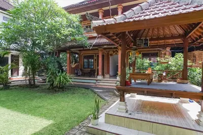 a house with a garden in front of it at Indopurejoy House - Komala Indah Cottages in Kuta