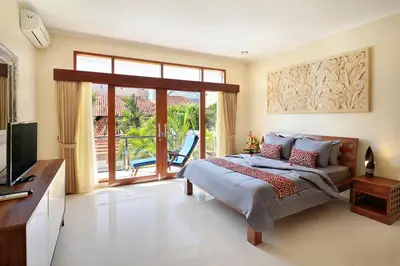 a bedroom with a bed and a sliding glass door at Villa Nova in Legian