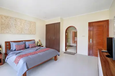 a bedroom with a bed and a flat screen tv at Villa Nova in Legian