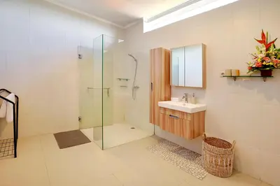 a bathroom with a glass shower and a sink at Villa Nova in Legian