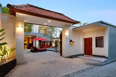 a house with a courtyard with a red umbrella at Villa Nova in Legian